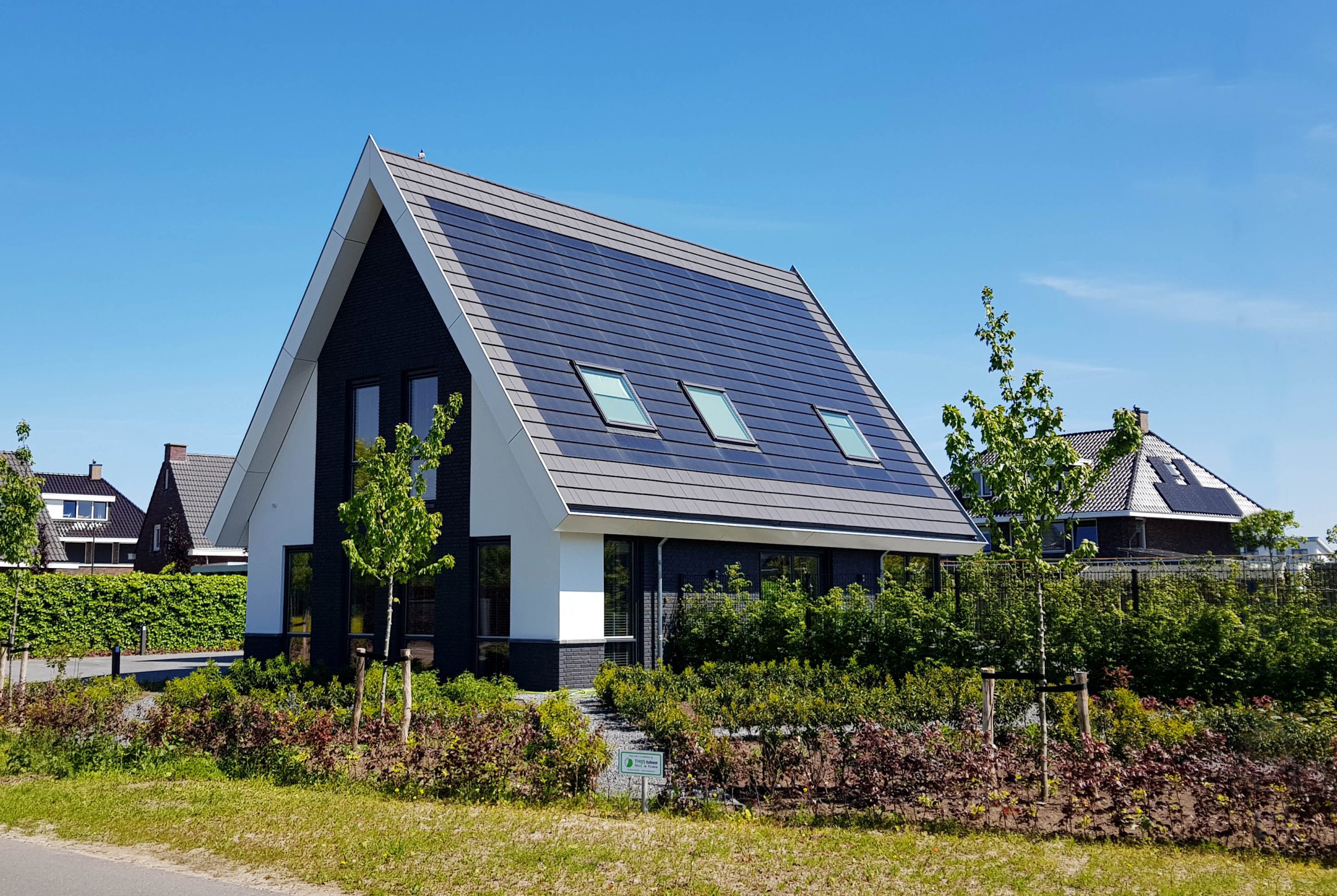 Solar shingles installed alongside standard asphalt shingles, visible difference in appearance